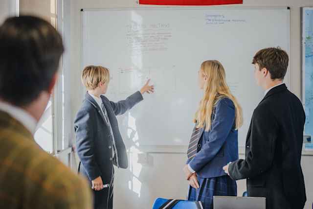Uppingham School - Students in classroom presenting in front of a white board during lessons Uppingham School - Students in classroom presenting in front of a white board during lessons