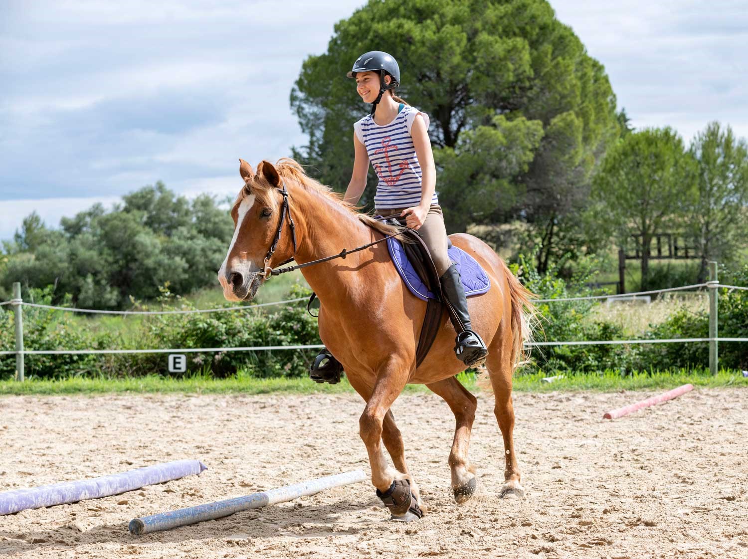 Heathfield Summer School - Glückliche Schülerin reitet auf dem Reitplatz