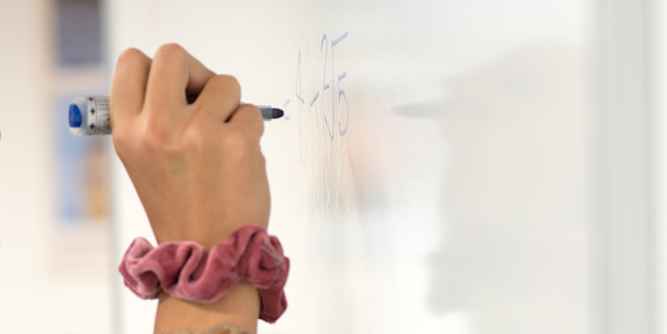 Schülerin schreibt auf Tafel Schülerin schreibt auf Tafel