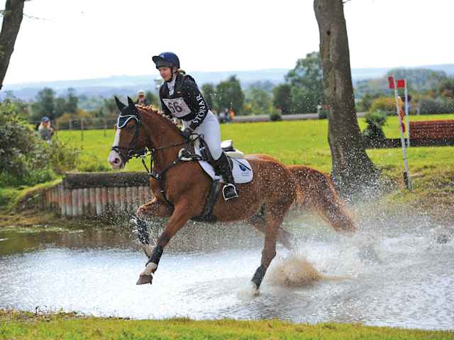 Stonar School - Schülerin bei einem Equestrian Reitwettbewerb Schülerin reitet durch ein Wasserhindernis