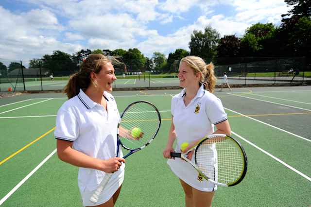 Repton School - Schülerinnen unterhalten sich auf dem Tennisplatz Repton School - Schülerinnen unterhalten sich auf dem Tennisplatz