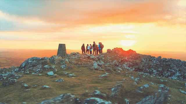 Mount Kelly College - Students on a mountain top druing sunrise Mount Kelly College - Students on a mountain top druing sunrise