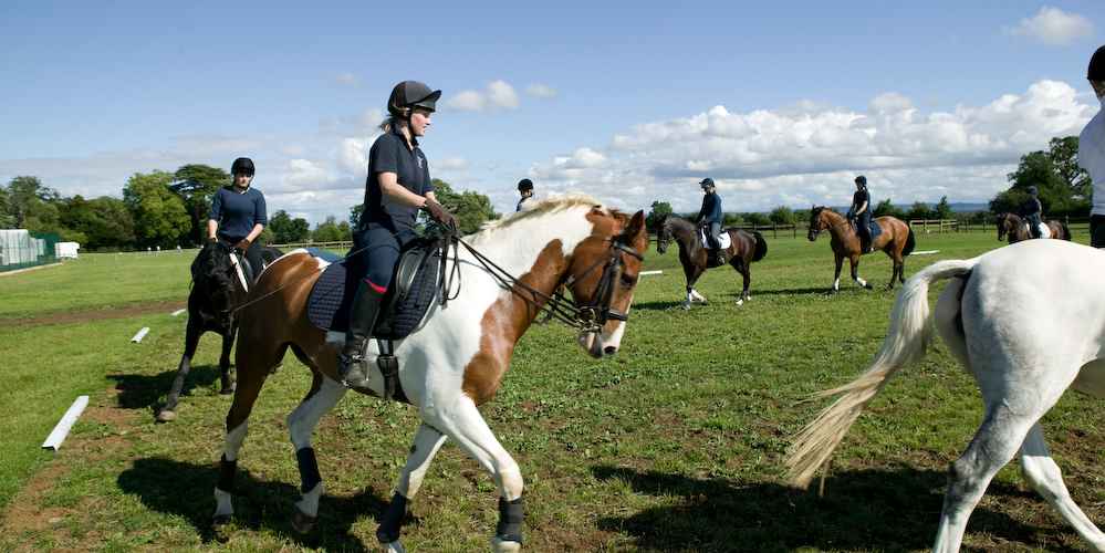 Stonar School - Pupils having riding lessons on campus Die Schüler reiten auf einem Reitplatz der Schule auf eigenen Pferden und auf Pferden der Schule