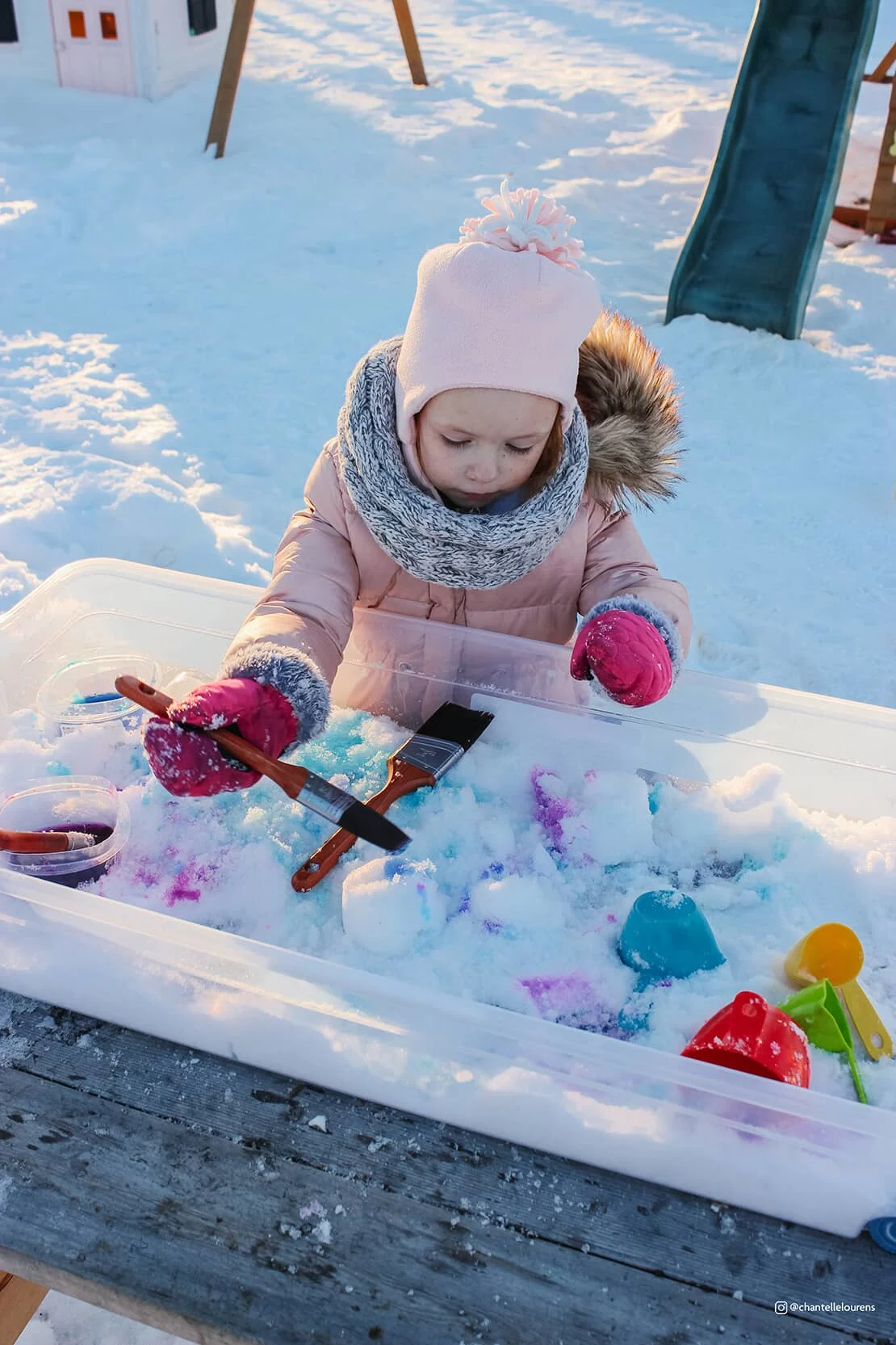 A child paints the snow. 