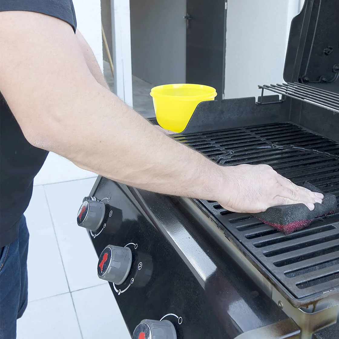 Someone cleans the grill.