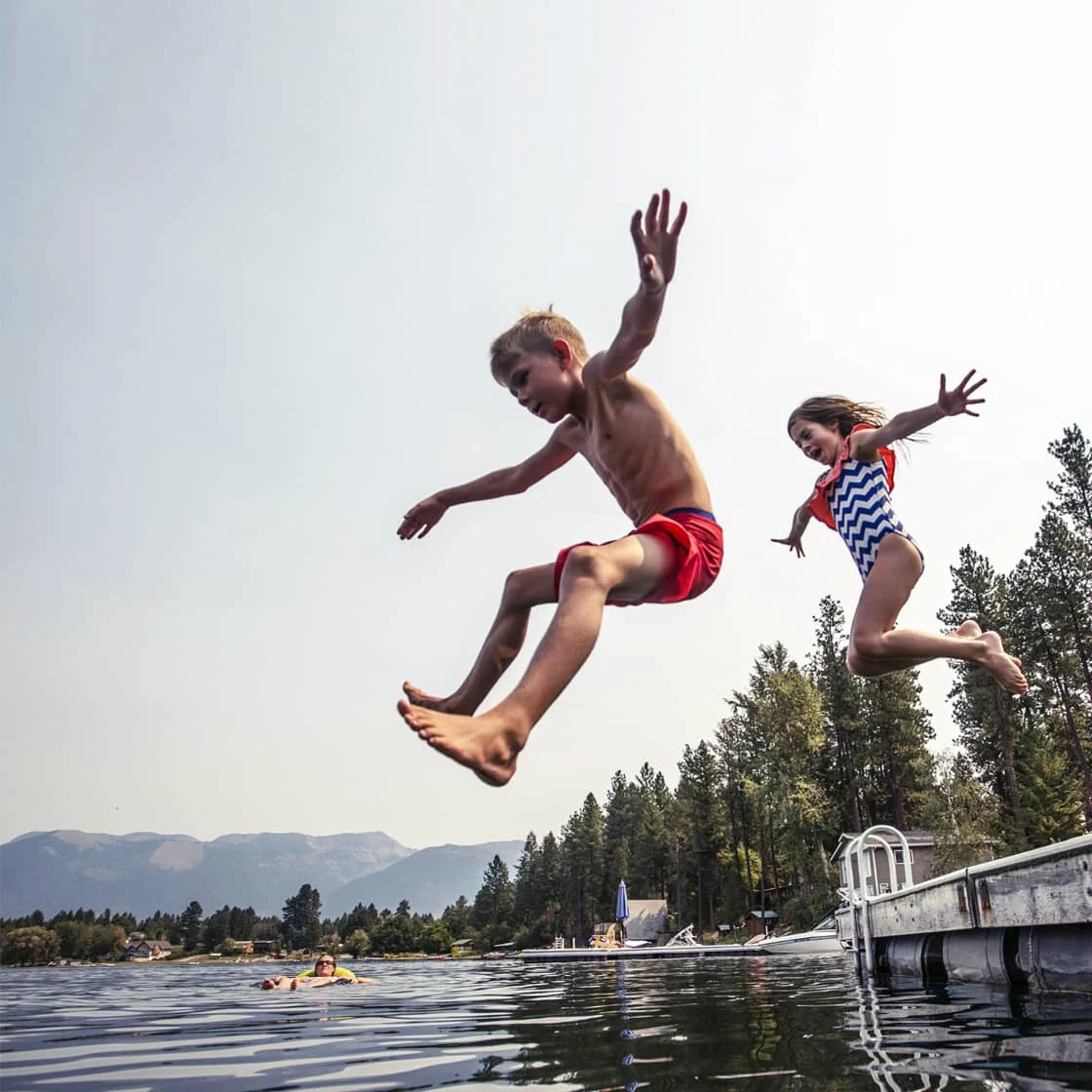 Kids jumping into a lake