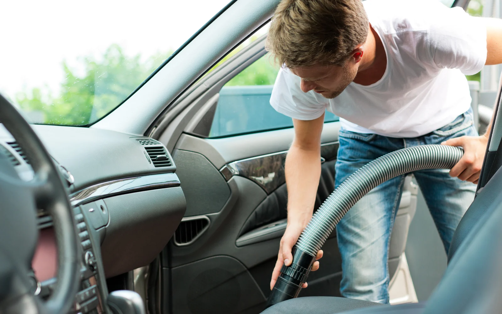 Quelqu'un passe l'aspirateur dans l'intérieur de sa voiture