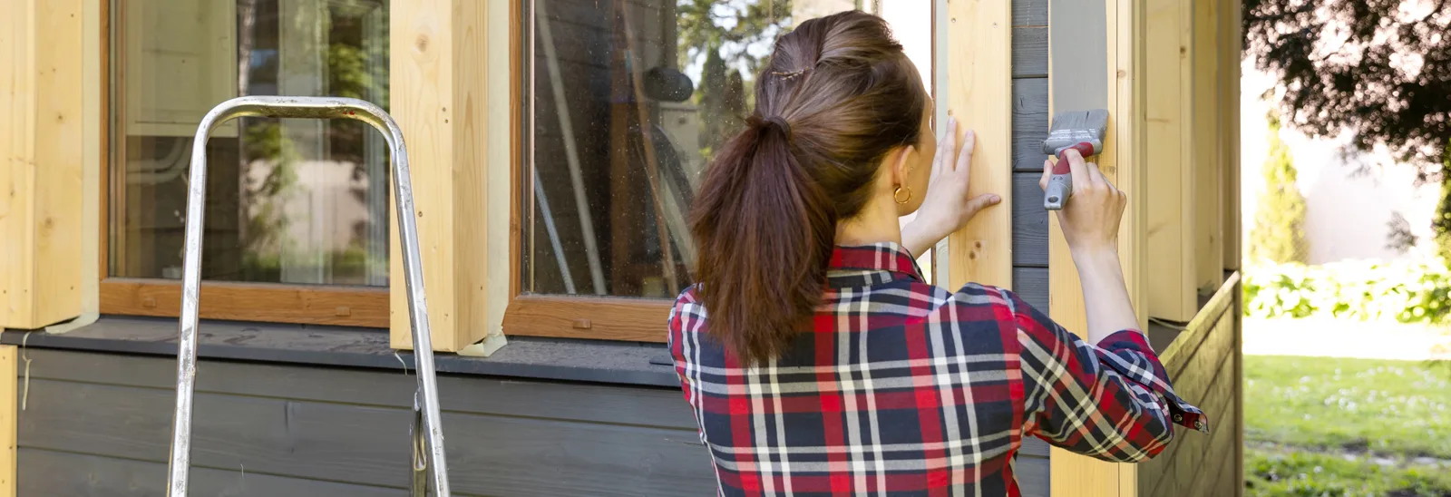Woman applying exterior paint