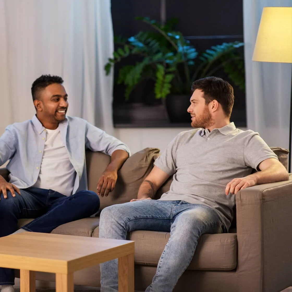 Two men sitting in a house lit up at night