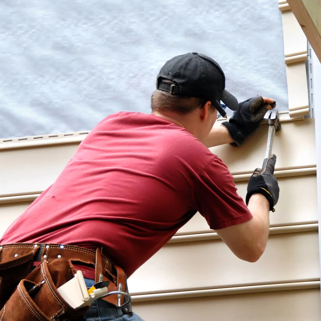 Someone repairs the siding
