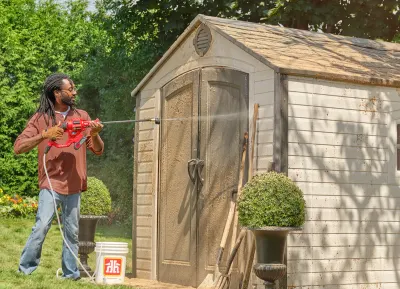 A homeowner using a pressure washer