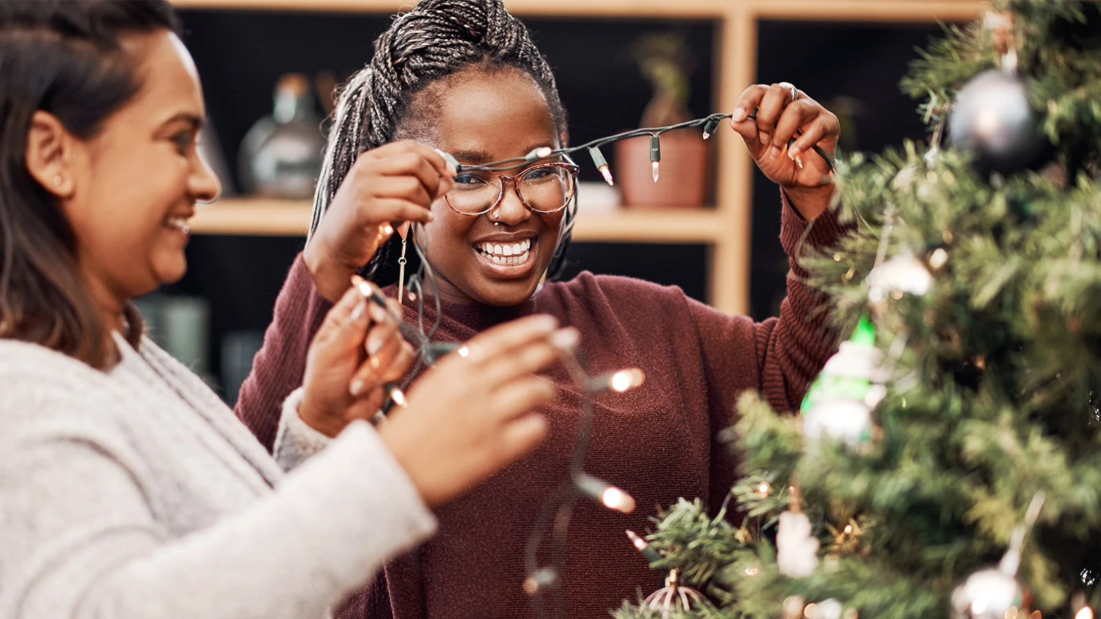 Deux personnes enfilant des lumières de Noël