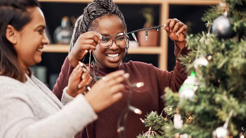 Deux personnes enfilant des lumières de Noël