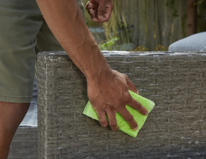 A man washes patio furniture