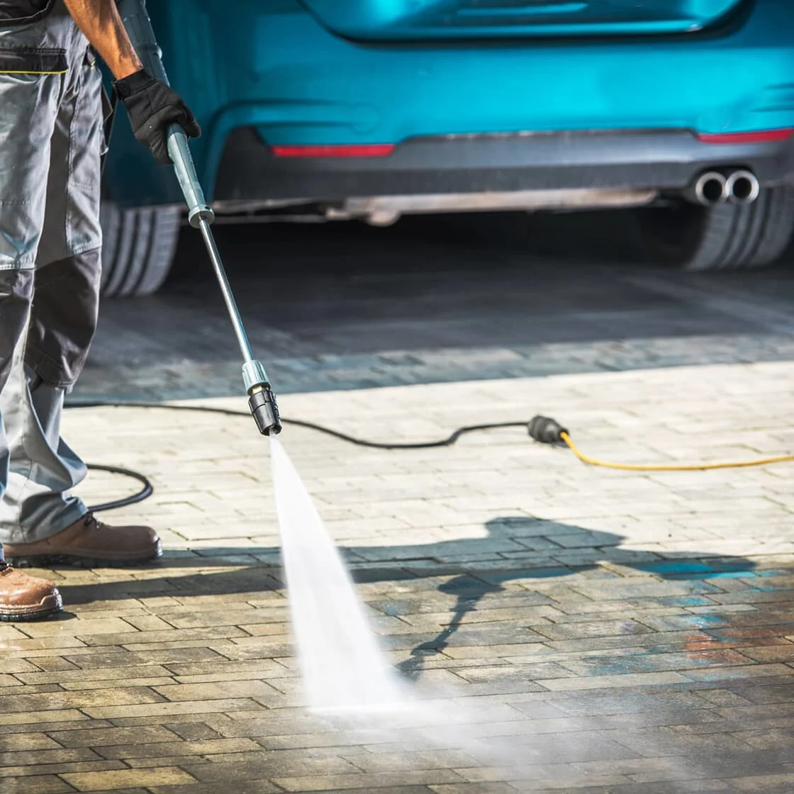 Someone cleans the driveway with a power washer.