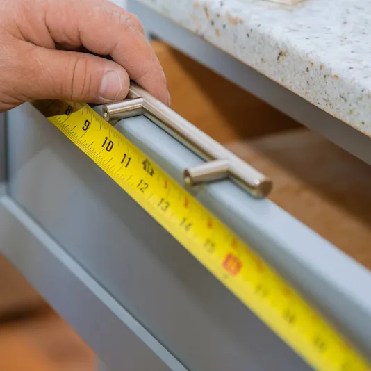 closeup on cabinet hardware against a blue drawer