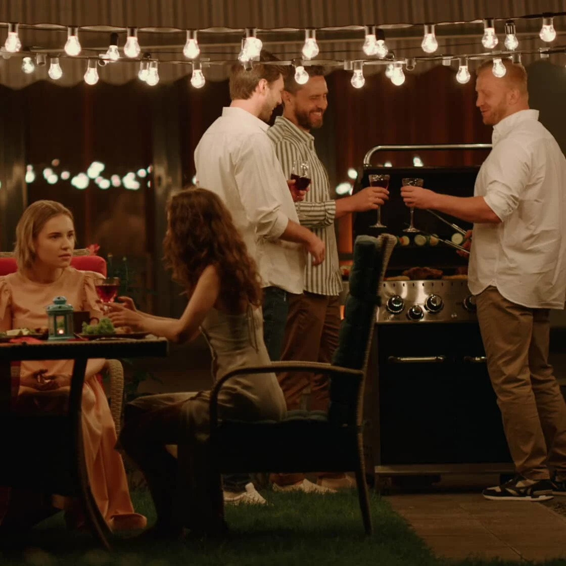 A group of friends have dinner outdoors.