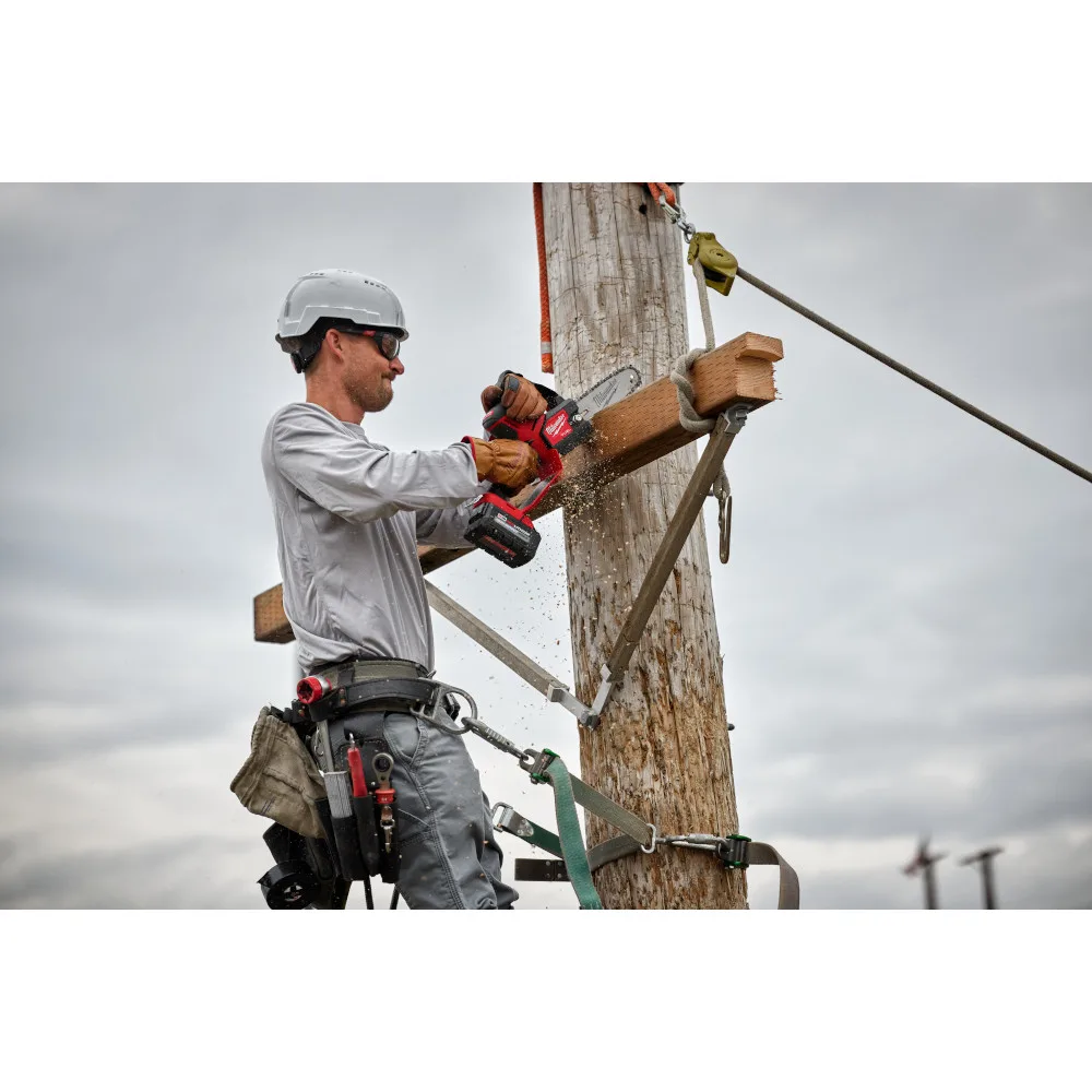 A man uses a Milwaukee drill on a telephone pole