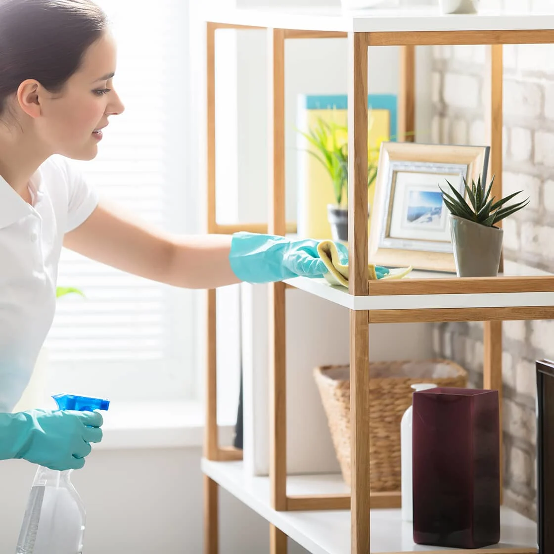 Someone cleans a wooden shelf