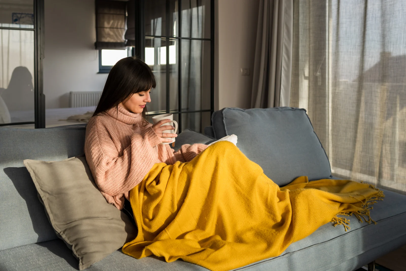 woman on couch with yellow throw blanket