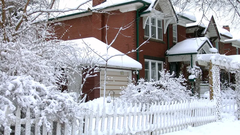 Il neige à l'extérieur de la maison
