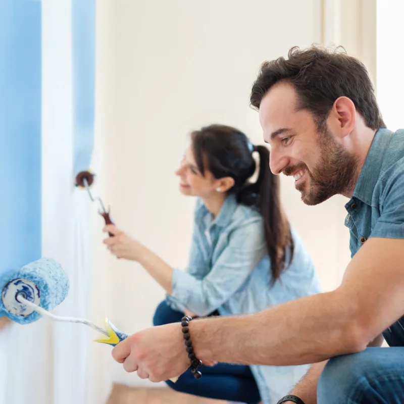 Un couple peignant ses murs en bleu
