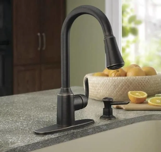 Two hold kitchen faucet installed on two holed sink with soap dispenser