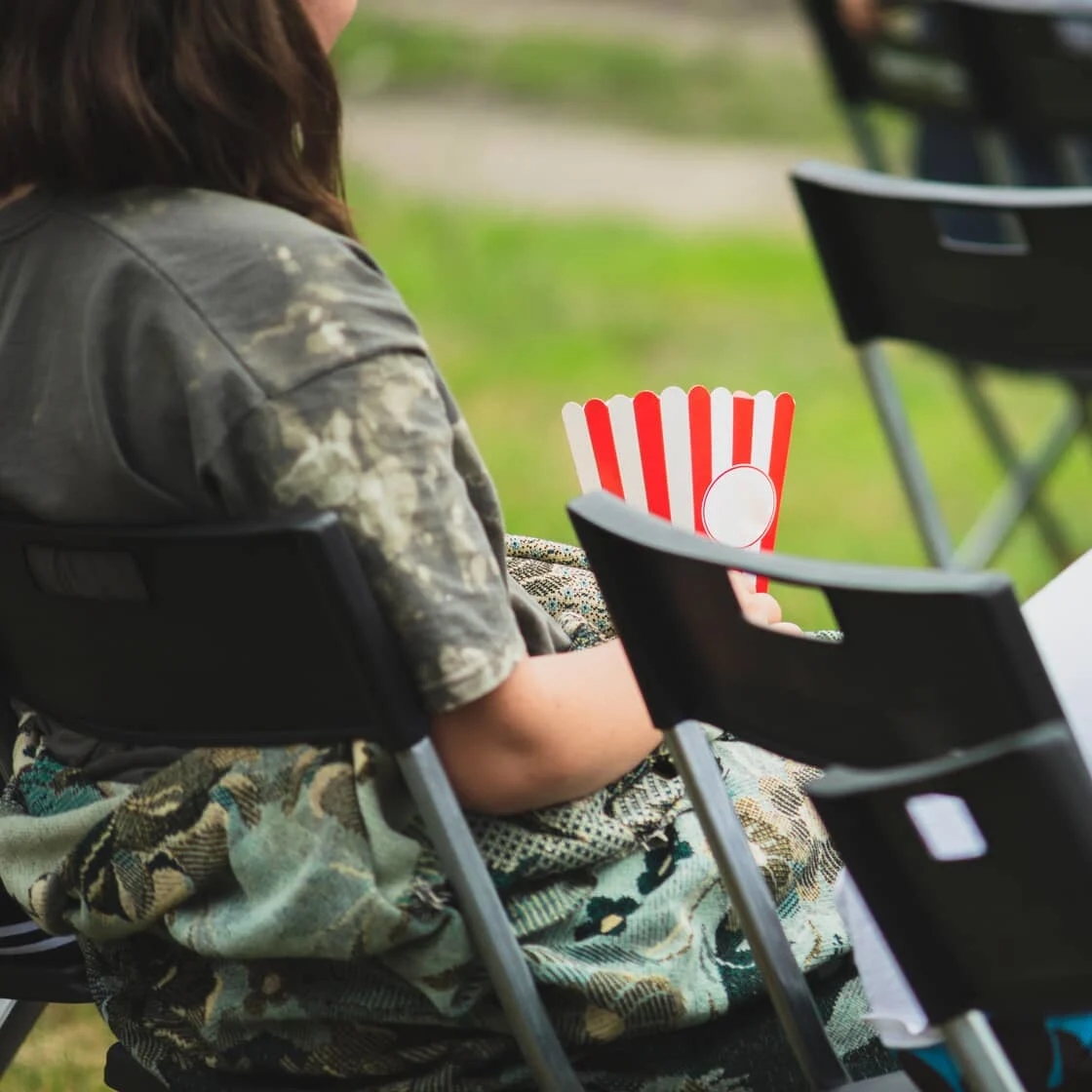 Someone sits in a chair outdoors.