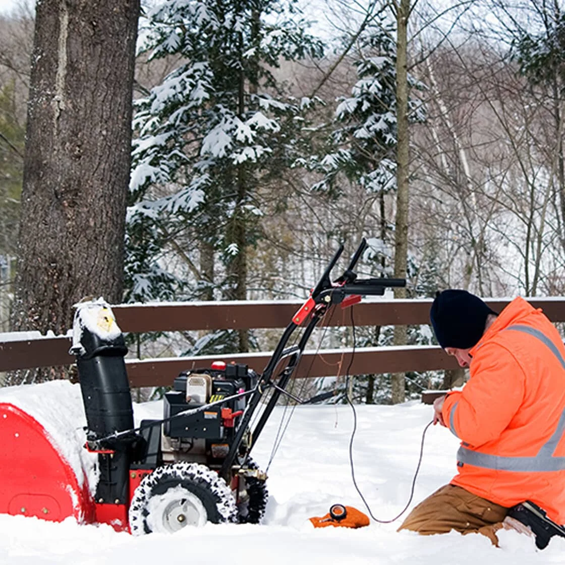 Someone fixes a snow blower.