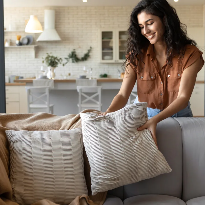 Woman arranging throw pillows on a couch