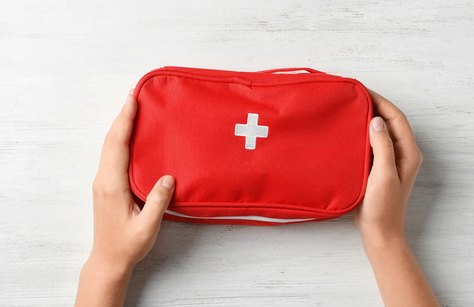 Someone holding red emergency kit