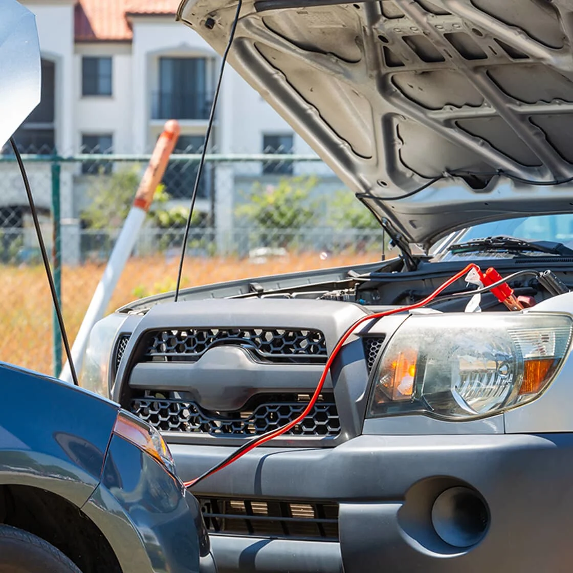 Two cars are connected by jumper cables