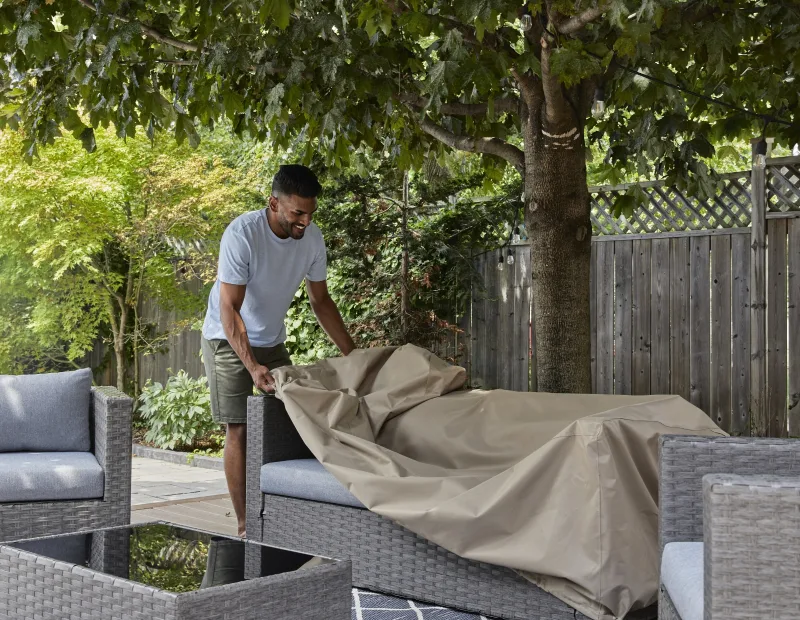 A man applying furniture cover