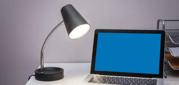 Une lampe de bureau et un ordinateur 