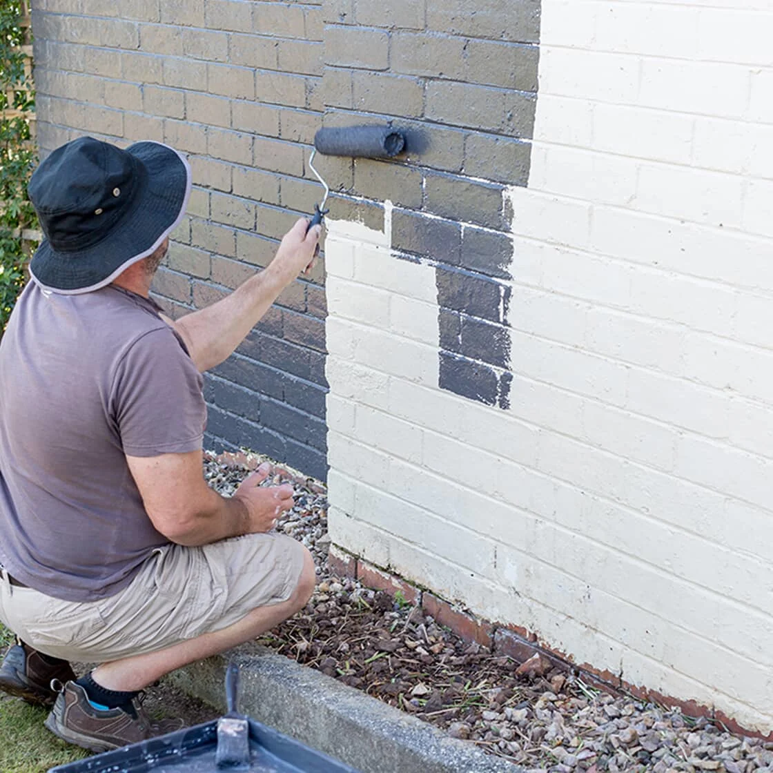 Someone painting brick
