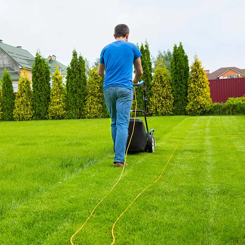 A man pushes a lawn mower
