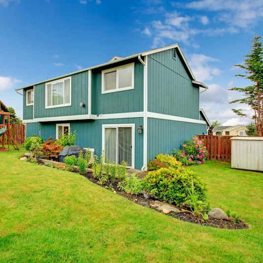 nicely landscaped home exterior with fence