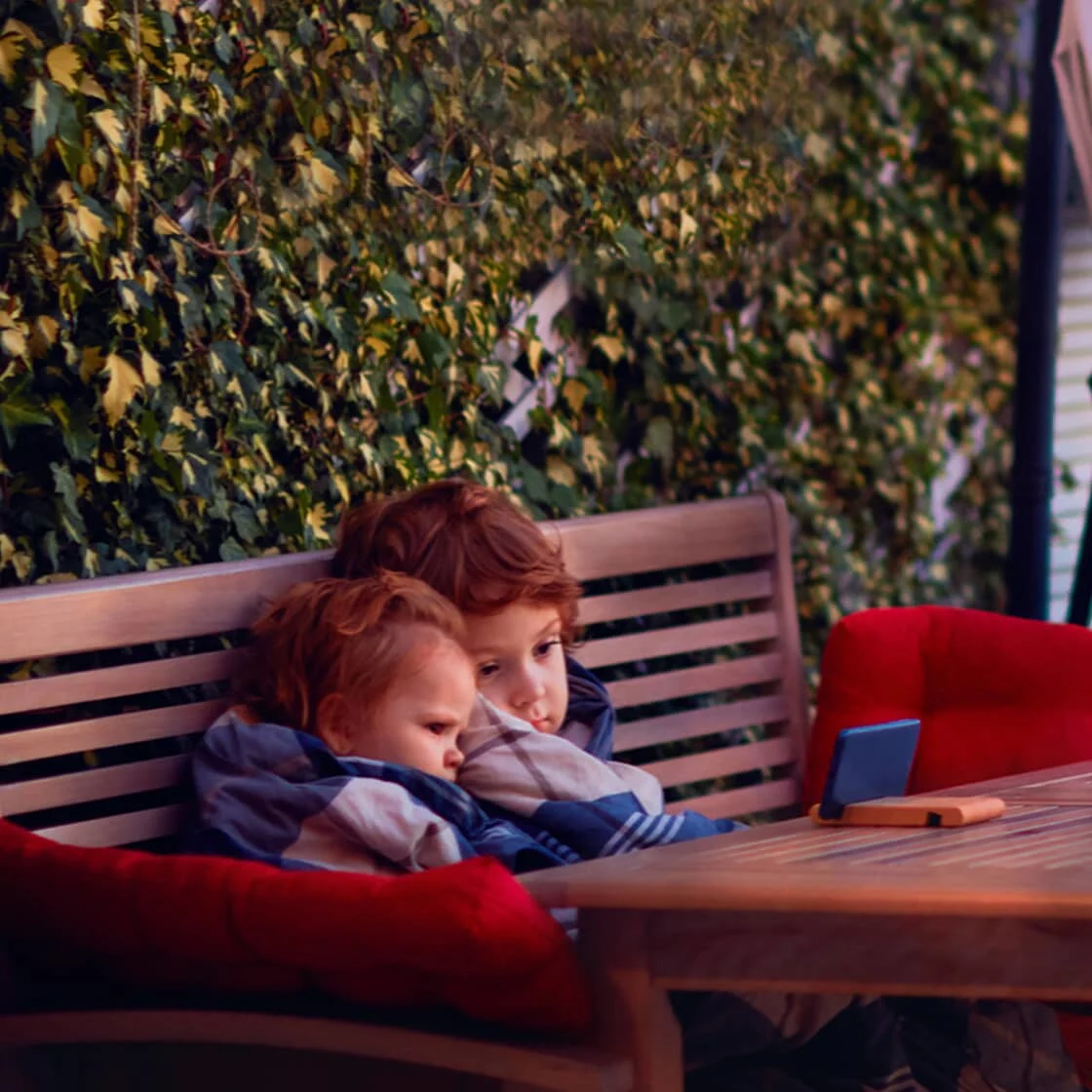 Two kids sit outside.
