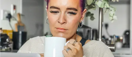 Woman drinking from a white mug
