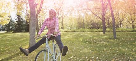 Billede af en kvinde, der cykler. Billedet illustrerer en kvinde, der lever og har det godt som sædvanlig, selvom hun har menstruation.