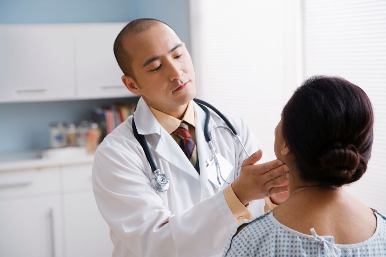Doctor checking woman's nodes