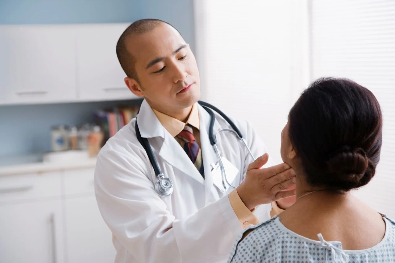 Doctor checking woman's nodes