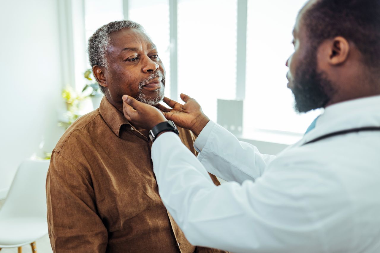Doctor checking elderly man's lymph nodes