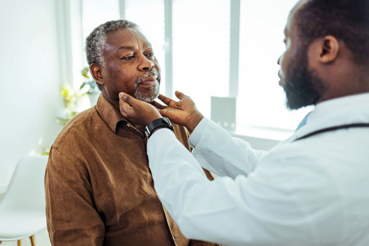 Doctor checking elderly man's lymph nodes