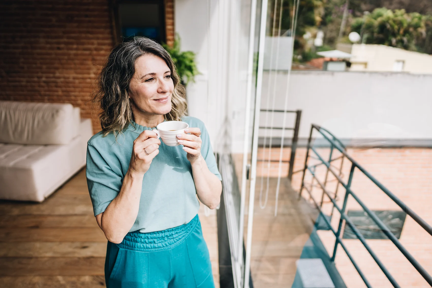Woman enjoys a view while drinking tea