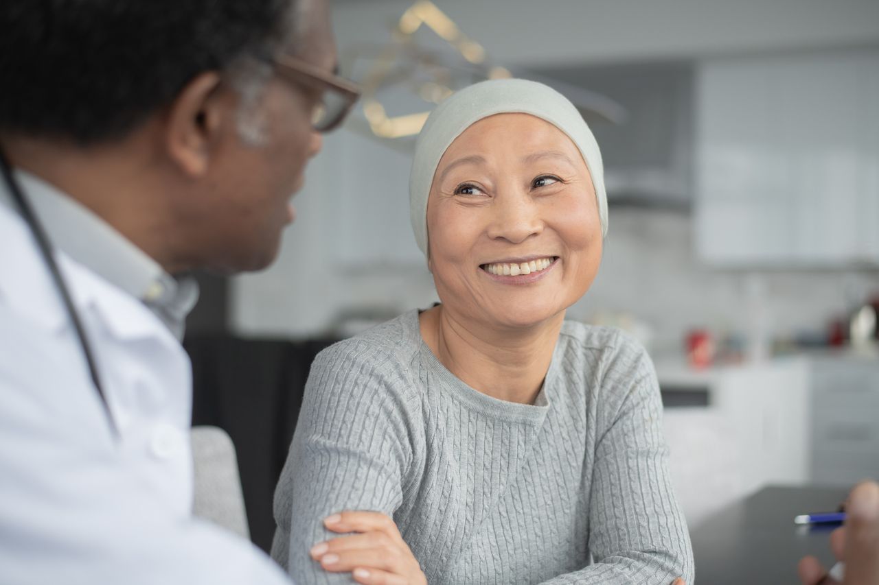 Woman with cancer smiling at her doctor
