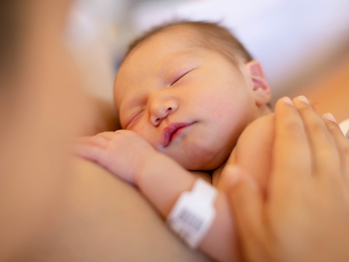 A newborn lays on its mother's chest