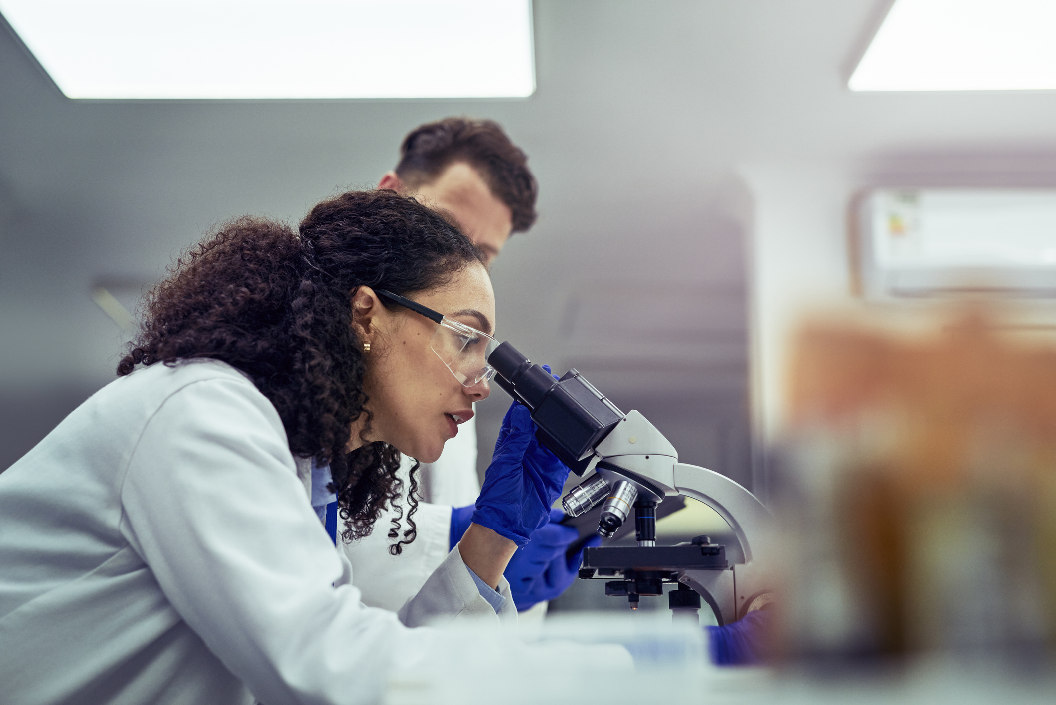 Female scientist looking through microscope