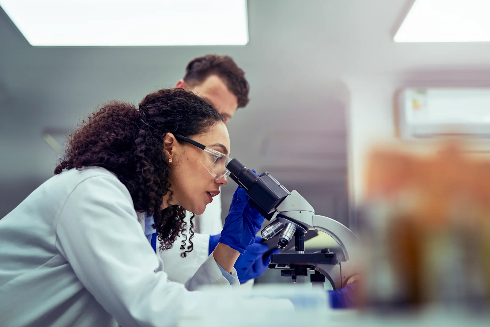 Female scientist looking through microscope