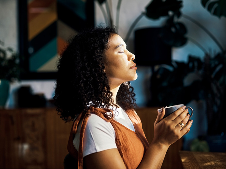 Woman closing her eyes holding a mug